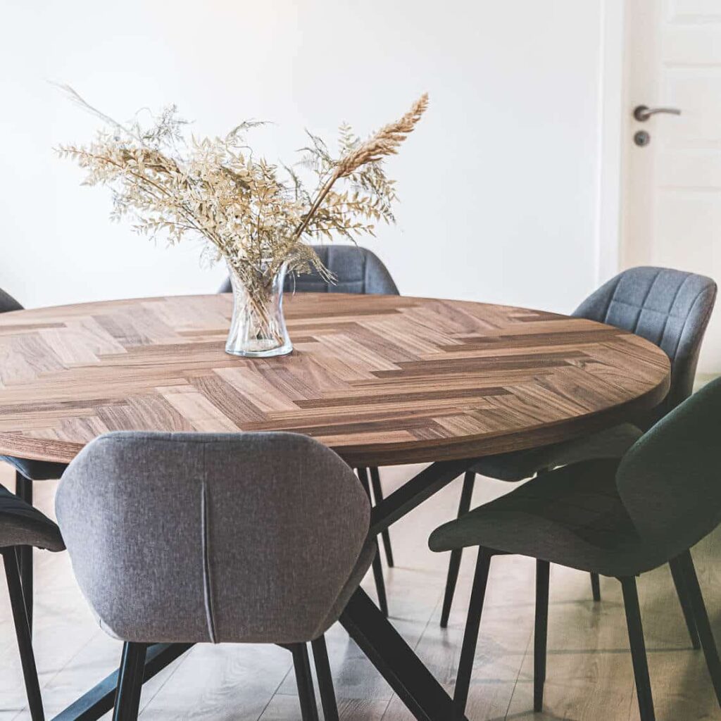 Billede af Freja – Rundt sildebensbord i valnød fra siden med en vase på bordet